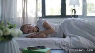 美丽的金发女子醒来在床上，立即开始查看她的智能手机清晨躺在她的一边